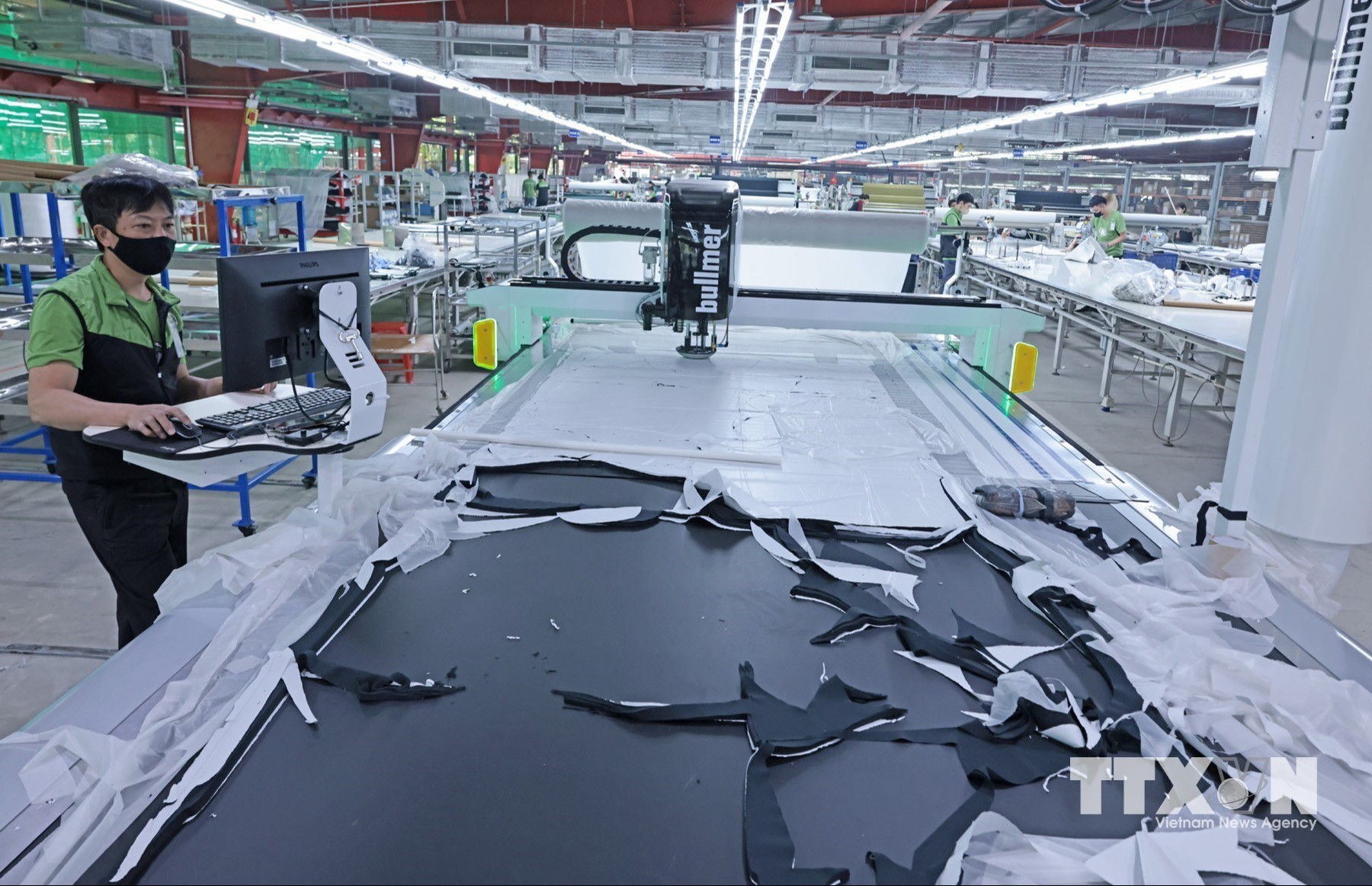 Công nhân điều khiển máy cắt tự động tại Công ty Maxport Thái Bình. (Ảnh: Trần Việt/TTXVN)